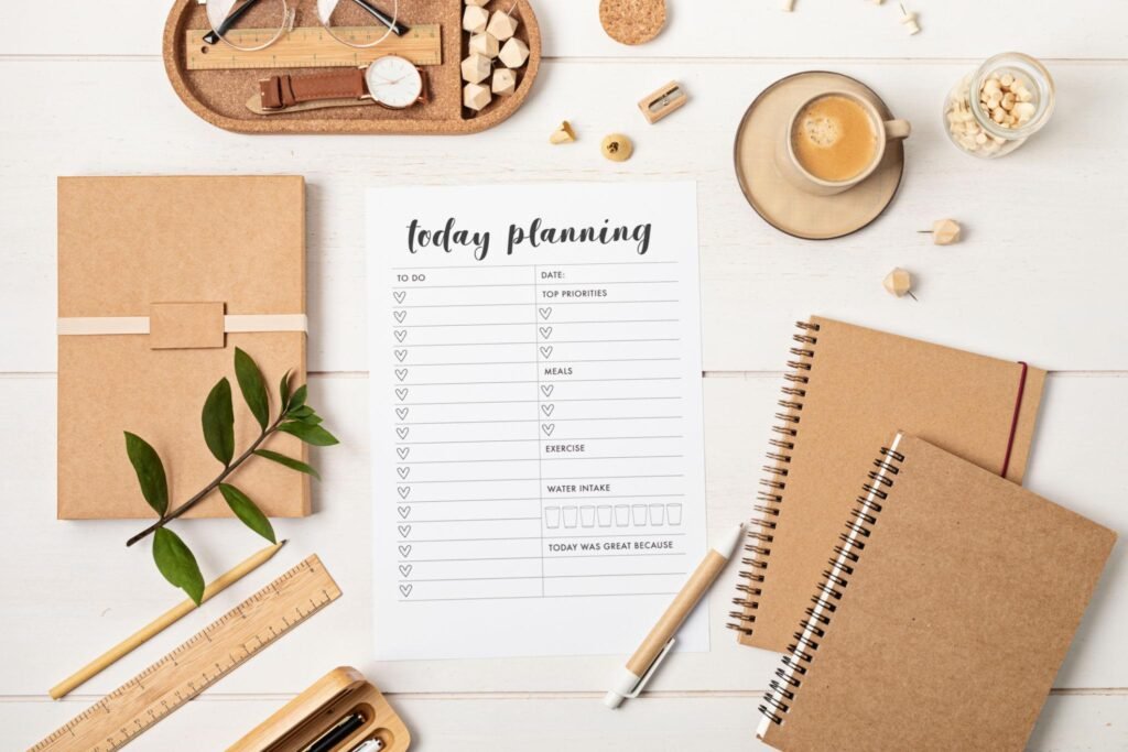 A minimal flat lay of a planner, checklist, tea, and plant symbolizing simple daily habits.